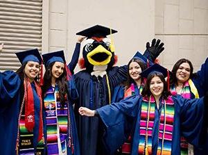 密歇根州立大学丹佛分校的毕业生在2024年春季毕业典礼上与罗迪合影.